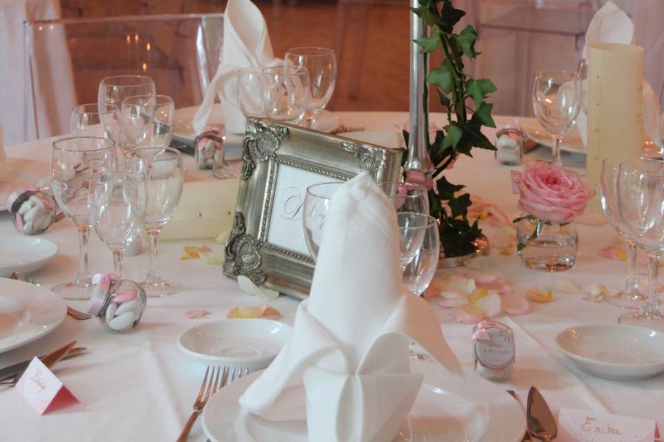 A wedding table laid with roses and silverware